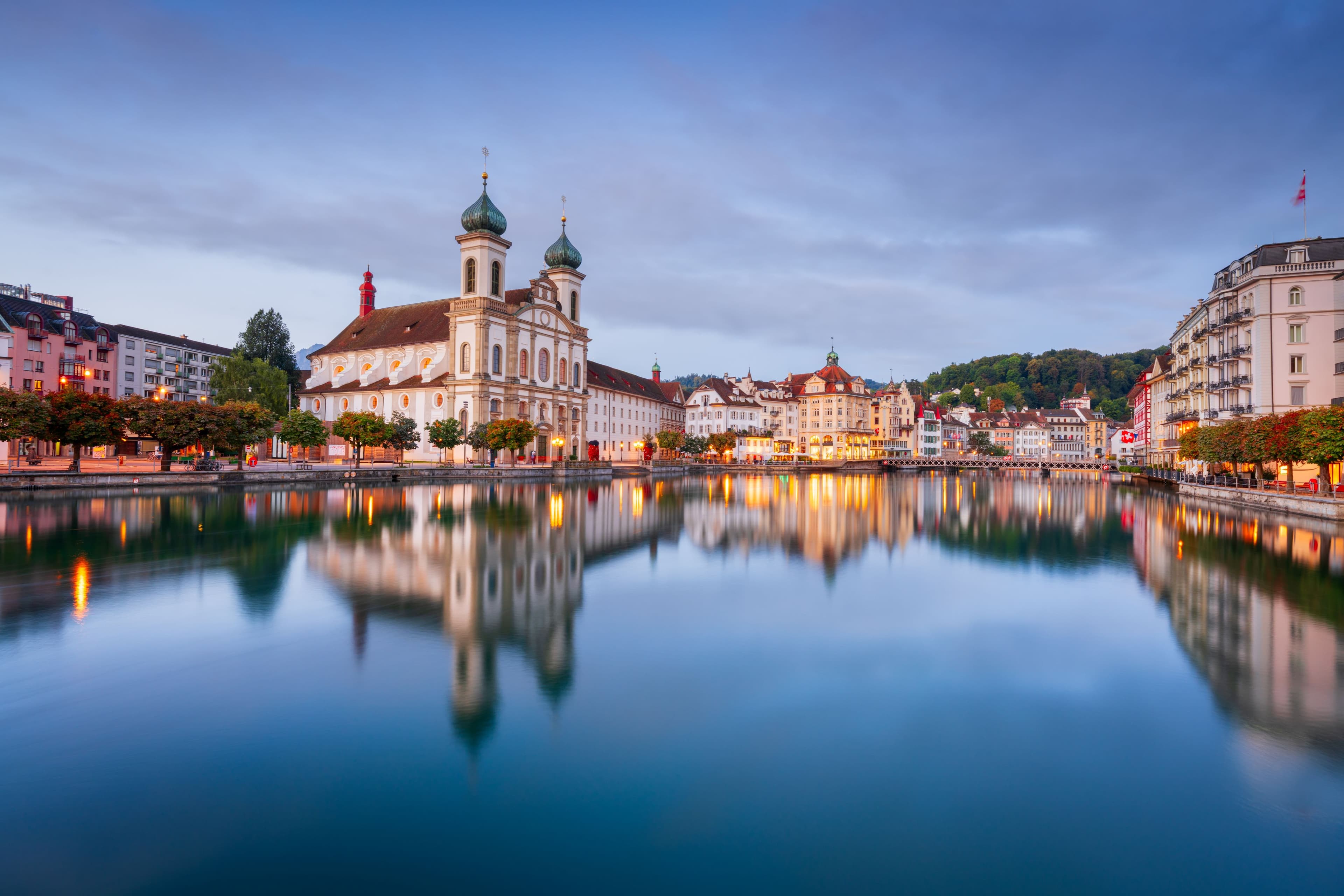 Jesuit Church reflecting in the Reuss river at dusk in old town Lucerne Switzerland